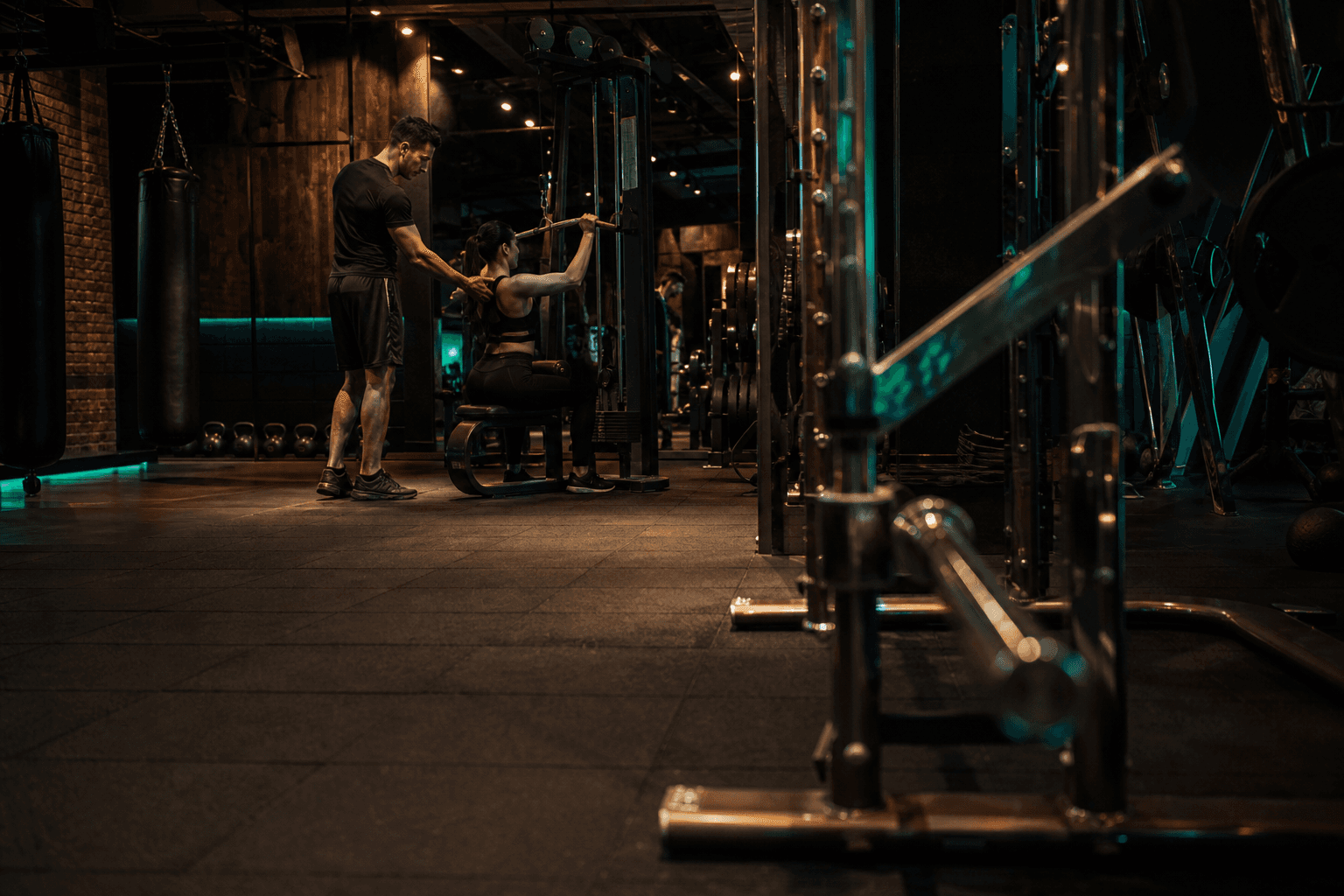Personal trainer acompanhando o aluno no treino, celular fora da série